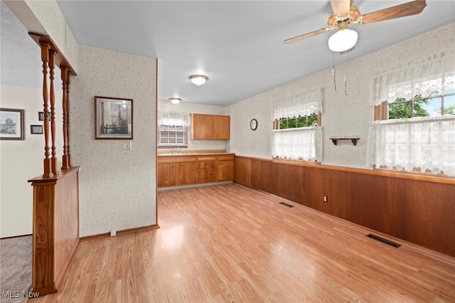 2100 Priscilla Ave NW, Massillon, OH 44647 - empty room with light wood-type flooring, plenty of natural light, ceiling fan, and wallpapered walls