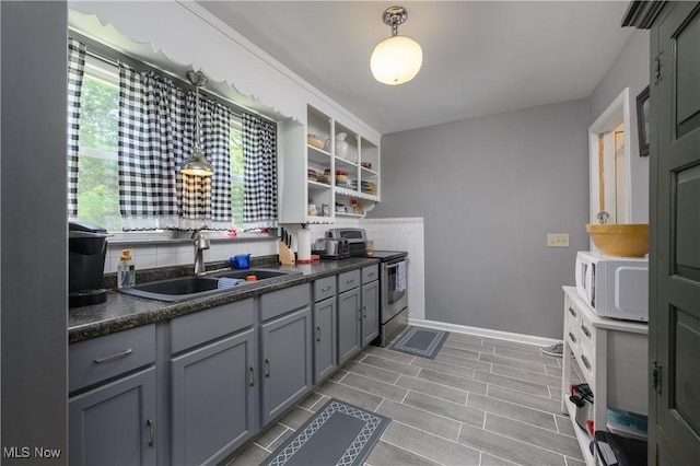 1209 Oak Ave SE, Massillon, OH 44646 - kitchen with white microwave, stainless steel electric stove, dark countertops, and gray cabinets