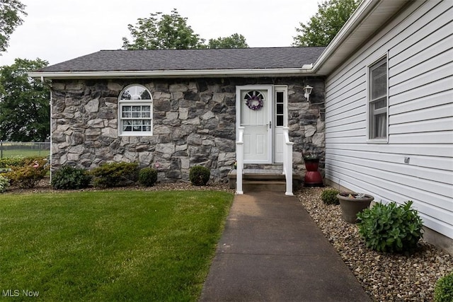 456 Hickory Ln, Salem, OH 44460 - view of exterior entry featuring stone siding, a yard, and a shingled roof