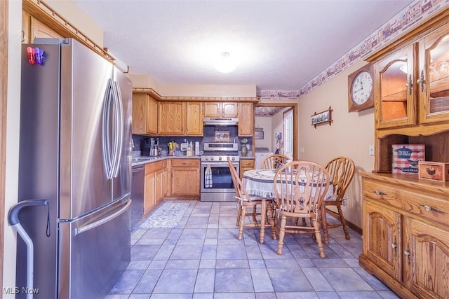 456 Hickory Ln, Salem, OH 44460 - kitchen with stainless steel appliances, extractor fan, light countertops, washer / dryer, and decorative backsplash