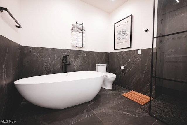 7363 Kempton Ct, Canfield, OH 44406 - bathroom with marble tiled flooring, a soaking tub, tile walls, wainscoting, and walk in shower