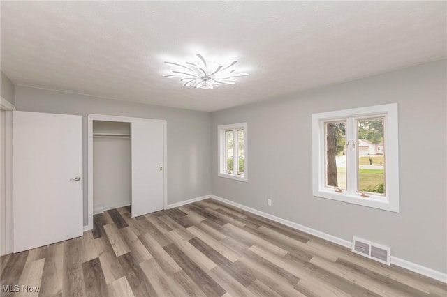 6114 Crossview Rd, Seven Hills, OH 44131 - unfurnished bedroom featuring multiple windows, light wood-style flooring, and a closet