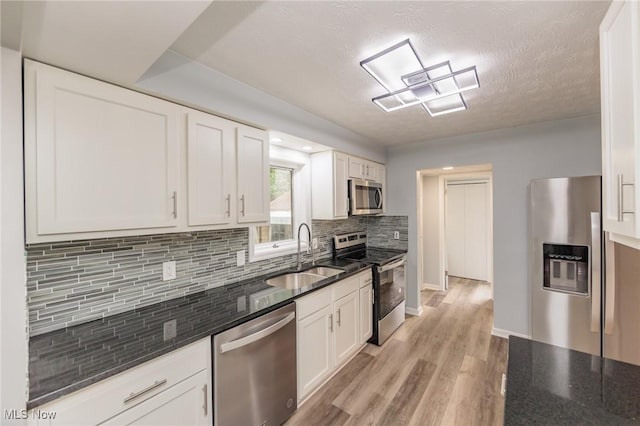 6114 Crossview Rd, Seven Hills, OH 44131 - kitchen featuring stainless steel appliances, decorative backsplash, white cabinets, light wood-style floors, and dark stone counters