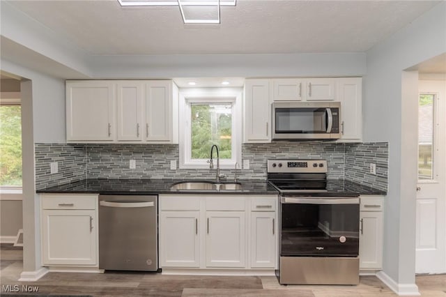 6114 Crossview Rd, Seven Hills, OH 44131 - kitchen featuring stainless steel appliances, light wood-type flooring, white cabinets, and decorative backsplash