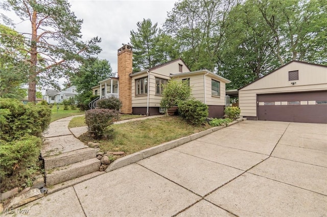 6114 Crossview Rd, Seven Hills, OH 44131 - view of front of home featuring a chimney, an outbuilding, a detached garage, and a front lawn