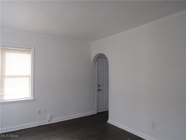 4078 E 154th St, Cleveland, OH 44128 - spare room featuring arched walkways, plenty of natural light, and dark wood-type flooring