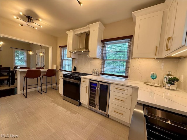 2337 Charney Rd, University Heights, OH 44118 - kitchen with beverage cooler, gas stove, wall chimney exhaust hood, and healthy amount of natural light