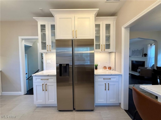 2337 Charney Rd, University Heights, OH 44118 - kitchen featuring stainless steel refrigerator with ice dispenser, tasteful backsplash, a fireplace, and white cabinetry