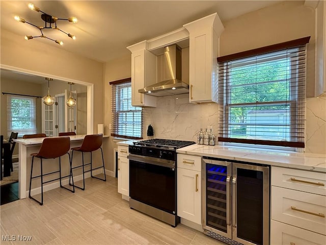 2337 Charney Rd, University Heights, OH 44118 - kitchen with range with gas cooktop, wall chimney range hood, beverage cooler, tasteful backsplash, and a chandelier