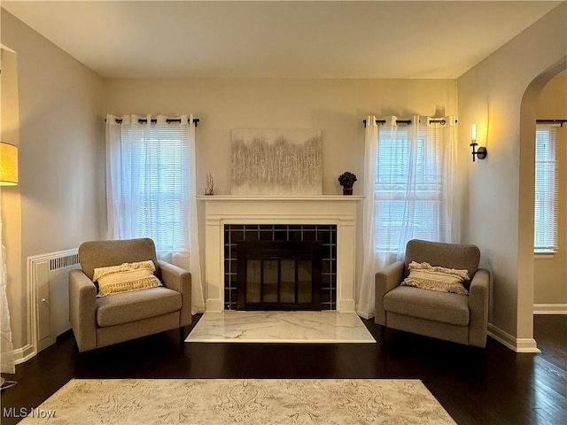 2337 Charney Rd, University Heights, OH 44118 - living area with arched walkways, wood finished floors, healthy amount of natural light, and a tiled fireplace