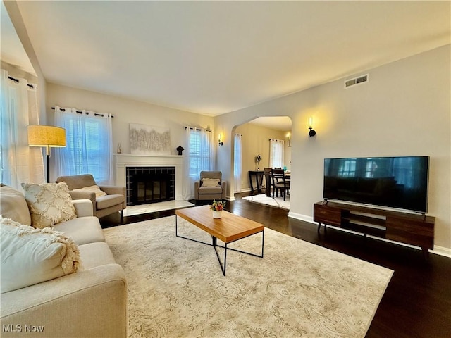 2337 Charney Rd, University Heights, OH 44118 - living area featuring arched walkways, dark wood finished floors, and plenty of natural light