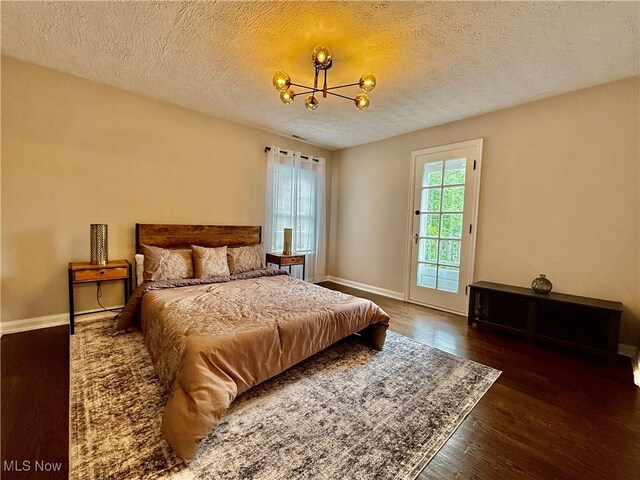 2337 Charney Rd, University Heights, OH 44118 - bedroom with a chandelier, wood finished floors, a textured ceiling, and access to exterior