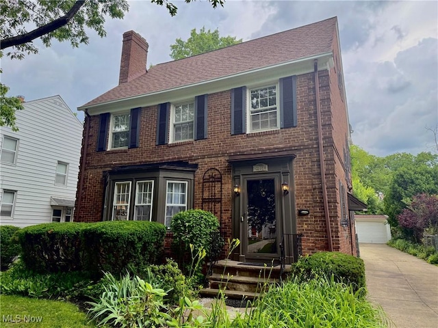 2337 Charney Rd, University Heights, OH 44118 - view of front of property featuring brick siding, a chimney, and a garage