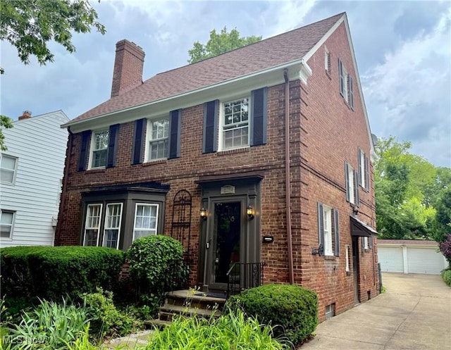 2337 Charney Rd, University Heights, OH 44118 - colonial inspired home with brick siding, a chimney, an outdoor structure, and a detached garage