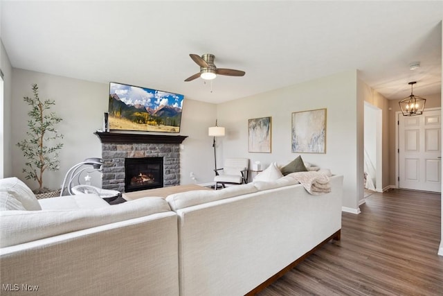 3523 Magnolia Dr, Lorain, OH 44053 - living room with dark wood-style floors, a fireplace, ceiling fan, and a chandelier