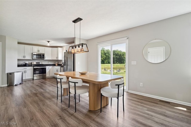 3523 Magnolia Dr, Lorain, OH 44053 - dining space featuring dark wood finished floors and baseboards