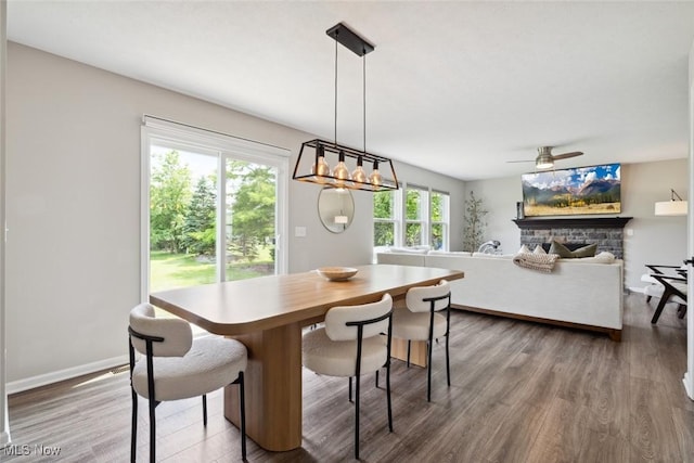 3523 Magnolia Dr, Lorain, OH 44053 - dining space with wood finished floors, ceiling fan, a stone fireplace, and a chandelier