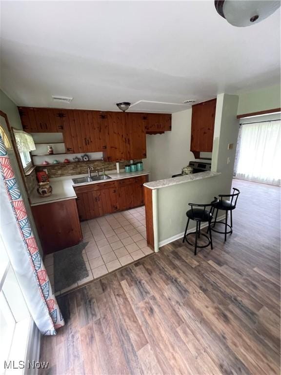 1781 Pleasant Valley Rd, Girard, OH 44420 - kitchen with a peninsula, brown cabinetry, light countertops, light wood finished floors, and a kitchen breakfast bar