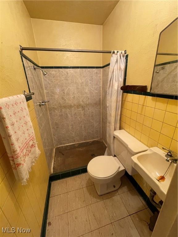 1781 Pleasant Valley Rd, Girard, OH 44420 - full bathroom featuring a stall shower, tile walls, and tile patterned flooring