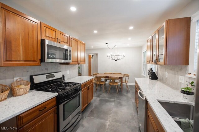 320 Brookfield Ave, Boardman, OH 44512 - kitchen with stainless steel appliances, recessed lighting, backsplash, light stone counters, and brown cabinetry
