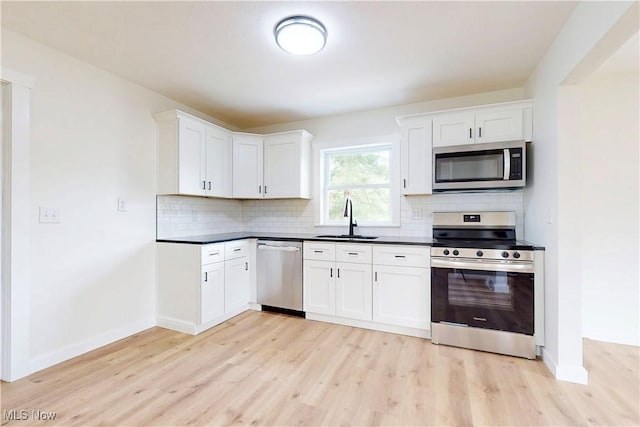 209 Beechwood Blvd, Wintersville, OH 43953 - kitchen with appliances with stainless steel finishes, light wood-style floors, decorative backsplash, and dark countertops
