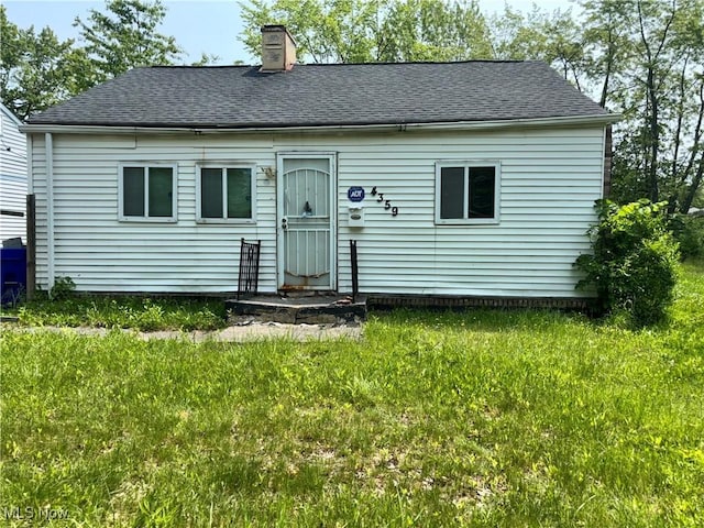 4359 E 143rd St, Cleveland, OH 44128 - view of front facade featuring a chimney, roof with shingles, and a front yard