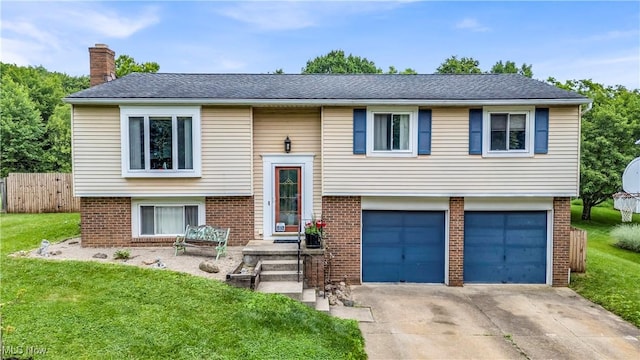 2869 Wexford Blvd, Stow, OH 44224 - split foyer home with a garage, concrete driveway, a chimney, and brick siding