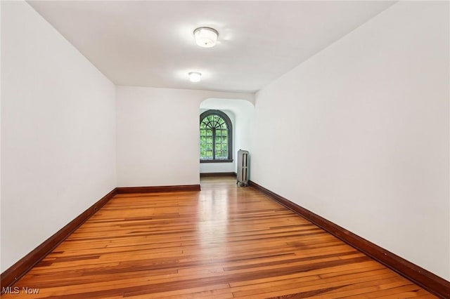 2820 W Park Blvd, Shaker Heights, OH 44120 - spare room with radiator, light wood-type flooring, and arched walkways