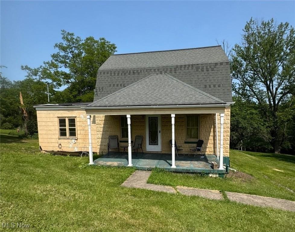 1151/2 Ekey St, Steubenville, OH 43953 - back of property with stone siding, a yard, and a shingled roof