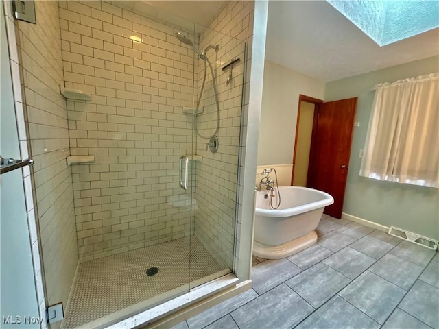 29123 Ridge Rd, Wickliffe, OH 44092 - full bath with a shower stall, a freestanding tub, a skylight, and tile patterned flooring