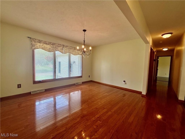 29123 Ridge Rd, Wickliffe, OH 44092 - empty room featuring wood finished floors, a chandelier, and a textured ceiling