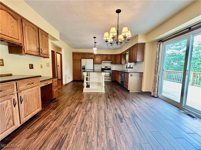 29123 Ridge Rd, Wickliffe, OH 44092 - kitchen with appliances with stainless steel finishes, dark wood-style floors, dark countertops, and a chandelier