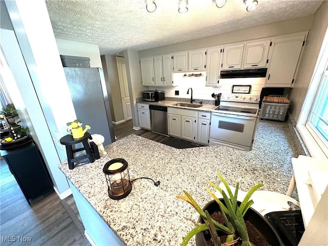 132 Dennis Dr, Cortland, OH 44410 - kitchen featuring stainless steel appliances, range hood, dark wood finished floors, a peninsula, and a textured ceiling