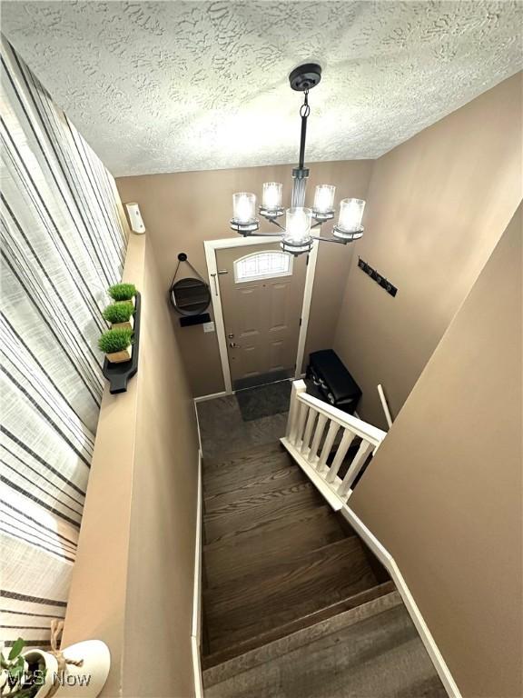 132 Dennis Dr, Cortland, OH 44410 - stairs featuring a chandelier and a textured ceiling