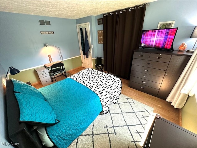 132 Dennis Dr, Cortland, OH 44410 - bedroom featuring light wood-style flooring and a textured ceiling