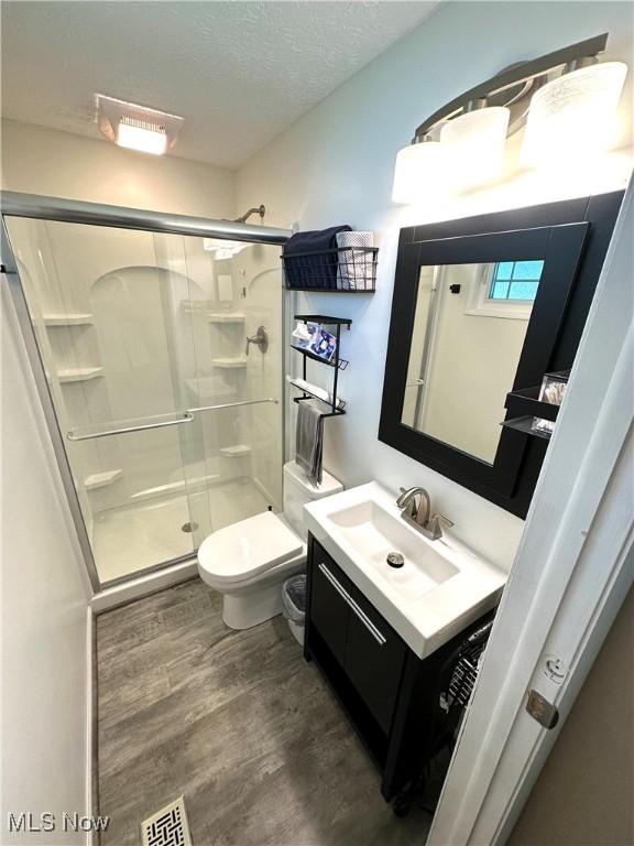 132 Dennis Dr, Cortland, OH 44410 - full bath featuring vanity, a stall shower, wood finished floors, and a textured ceiling