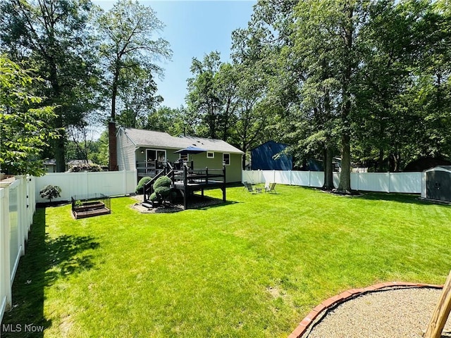 132 Dennis Dr, Cortland, OH 44410 - fenced backyard featuring a storage shed, a wooden deck, and a vegetable garden