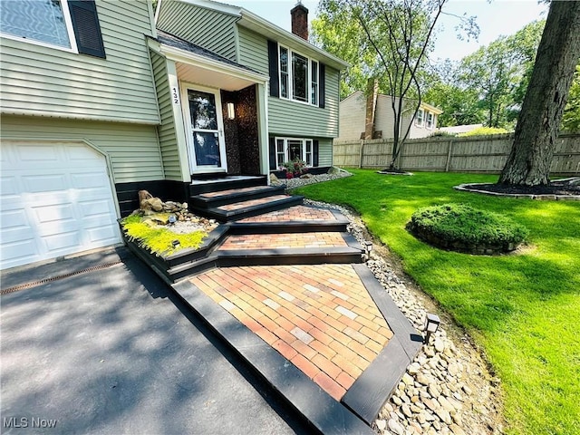 132 Dennis Dr, Cortland, OH 44410 - property entrance with an attached garage and a chimney