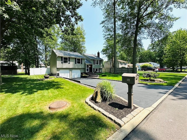 132 Dennis Dr, Cortland, OH 44410 - bi-level home with asphalt driveway, an attached garage, and a chimney