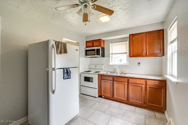 640 E 261st St, Euclid, OH 44132 - kitchen with white appliances, light countertops, a ceiling fan, tasteful backsplash, and brown cabinets