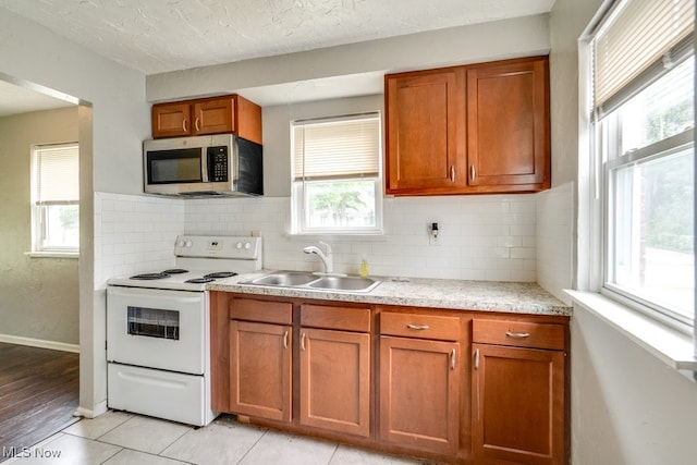 640 E 261st St, Euclid, OH 44132 - kitchen featuring stainless steel microwave, electric range, light countertops, healthy amount of natural light, and a textured ceiling