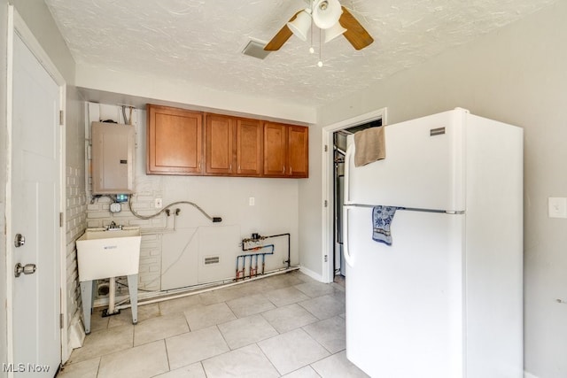 640 E 261st St, Euclid, OH 44132 - kitchen with freestanding refrigerator, brown cabinetry, ceiling fan, water heater, and light tile patterned floors
