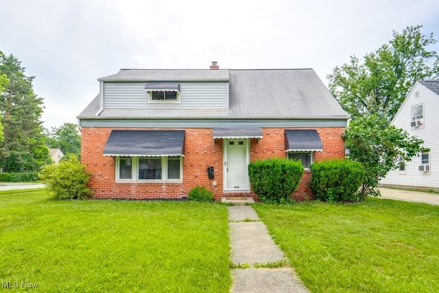 640 E 261st St, Euclid, OH 44132 - bungalow with brick siding, a front yard, and a chimney