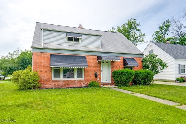 640 E 261st St, Euclid, OH 44132 - view of front of property featuring brick siding, a front yard, and a chimney