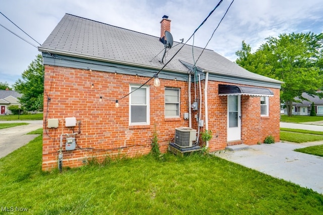 640 E 261st St, Euclid, OH 44132 - back of property featuring brick siding, a yard, and a chimney