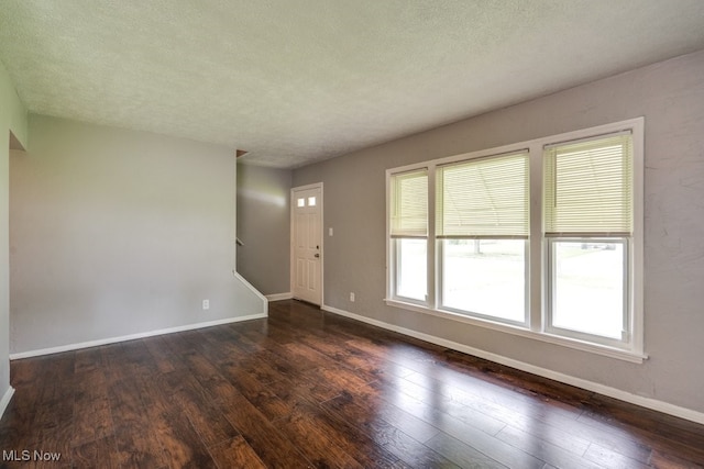 640 E 261st St, Euclid, OH 44132 - unfurnished living room with dark wood-style floors, stairway, and a textured ceiling