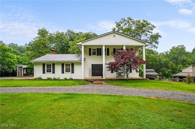 7436 Crory Rd, Canfield, OH 44406 - greek revival house featuring a chimney, a standing seam roof, a front lawn, and a metal roof
