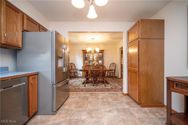 3661 Meander Reserve Cir, Canfield, OH 44406 - kitchen with appliances with stainless steel finishes, a chandelier, brown cabinetry, and decorative light fixtures