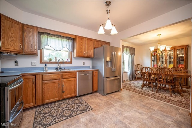 3661 Meander Reserve Cir, Canfield, OH 44406 - kitchen with appliances with stainless steel finishes, a chandelier, brown cabinets, and decorative light fixtures