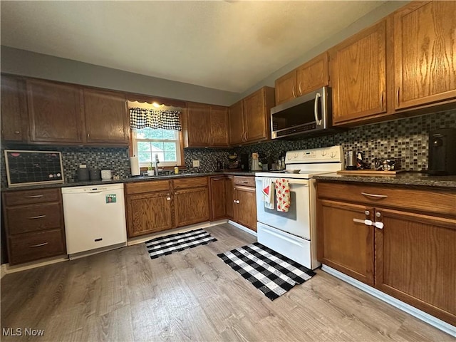5130 Winfield St NE, East Canton, OH 44730 - kitchen with white appliances, light wood-style flooring, tasteful backsplash, and dark countertops